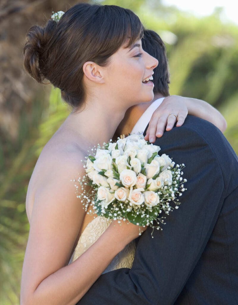 novio y novia sujetando ramo flores abrazados en su boda chapoo